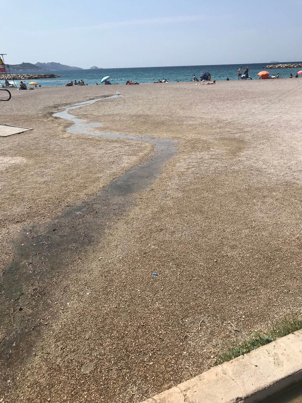 L'eau usée des douches s'écoule dans le sable et la mer